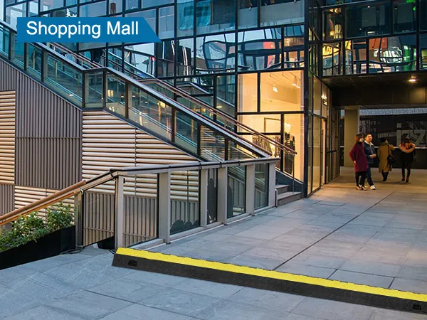 VEVOR cable protector ramp at shopping mall entrance with stairs and retail store in the background.