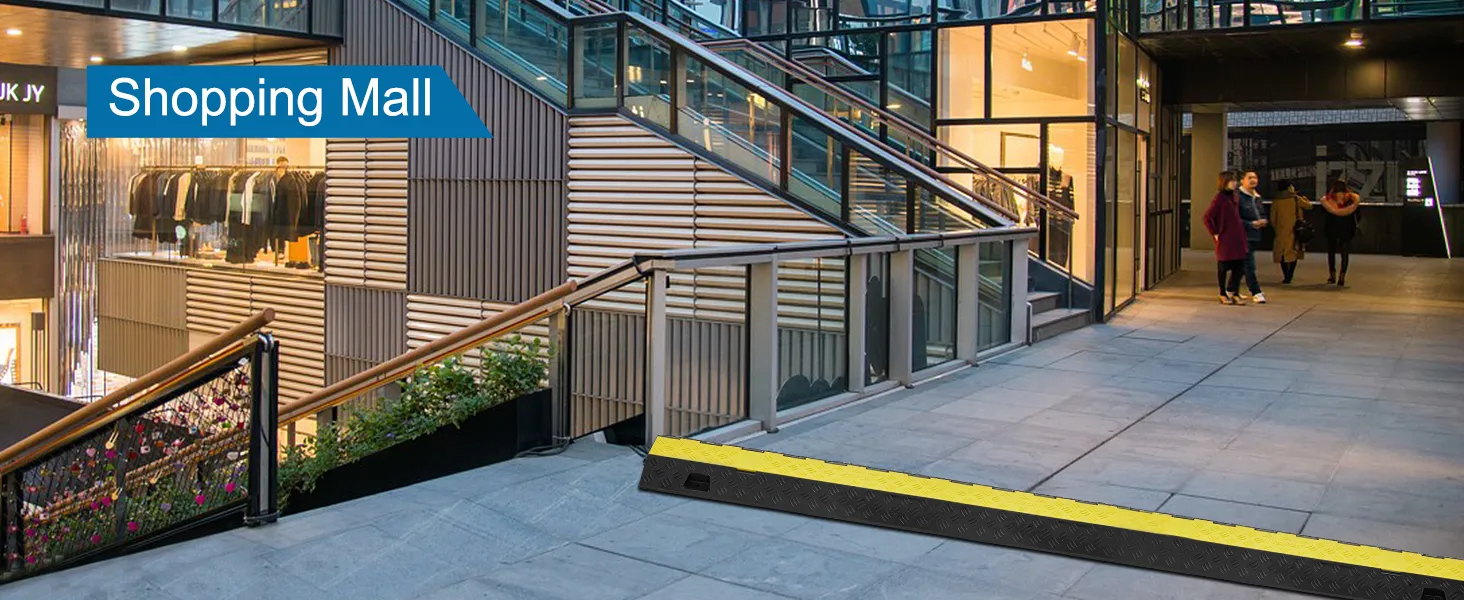 VEVOR cable protector ramp at shopping mall entrance with stairs and retail store in the background.