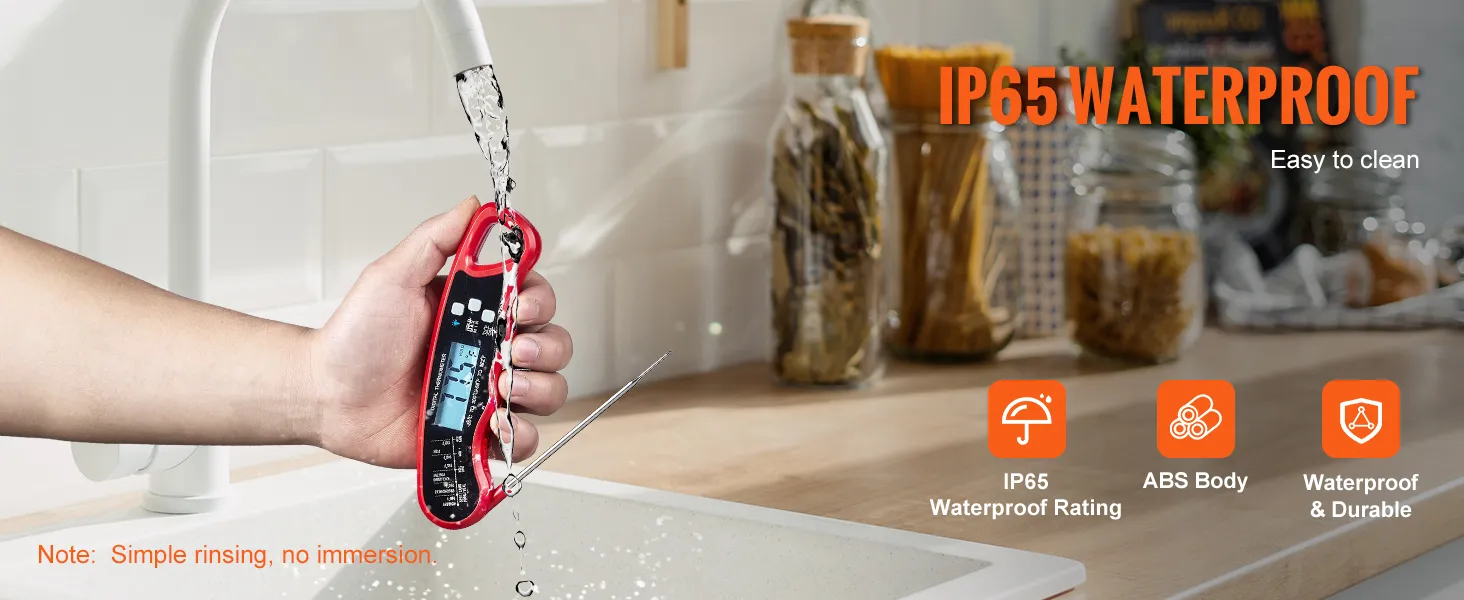 Enjuague a mano un termómetro de carne VEVOR rojo debajo de un grifo de cocina, con clasificación de impermeabilidad IP65.