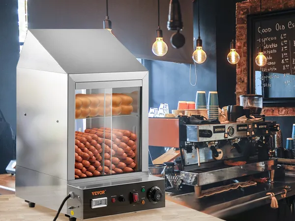 Vaporera para hot dogs VEVOR en una acogedora cafetería con paredes de ladrillo a la vista y bombillas colgantes.