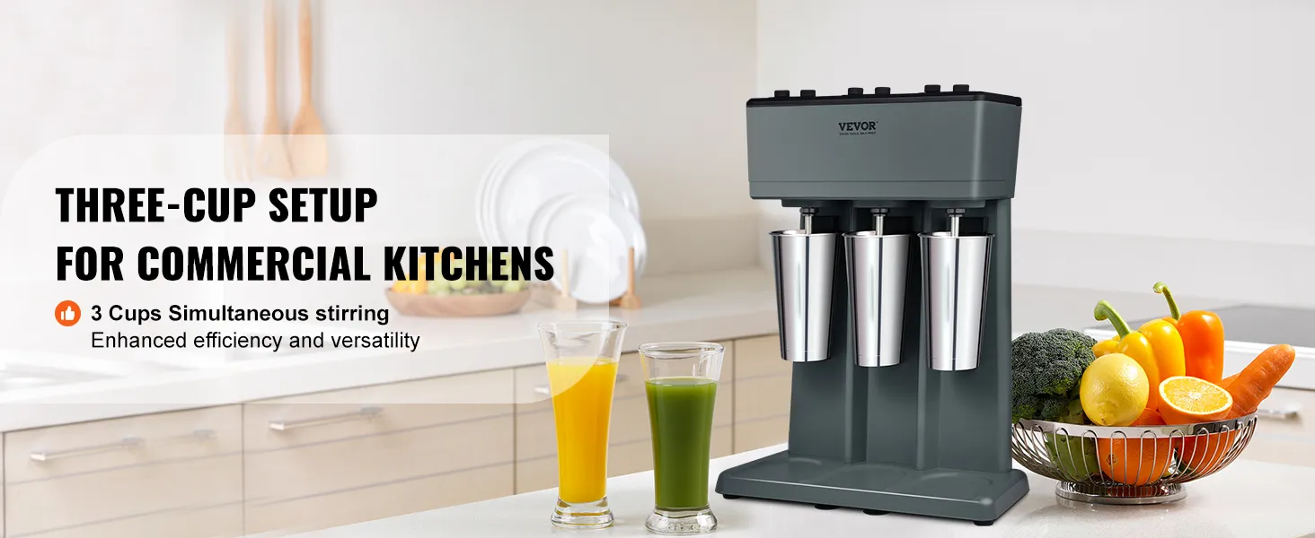 Máquina para hacer batidos VEVOR en una cocina con tres tazas de acero inoxidable y verduras frescas en la encimera.