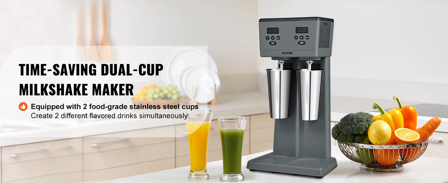 Máquina para hacer batidos VEVOR con dos tazas de acero inoxidable en una cocina moderna, rodeada de fruta fresca.