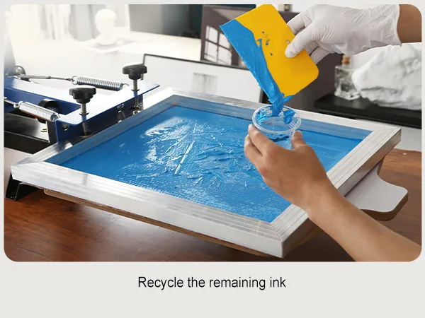 hand using squeegee to recycle blue ink in the VEVOR screen printing kit.