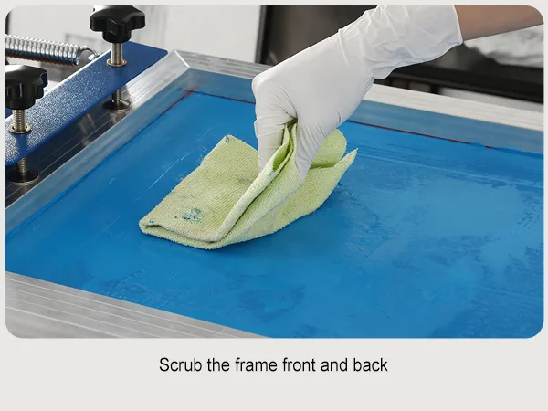 gloved hand scrubbing a blue screen frame using the VEVOR screen printing kit.