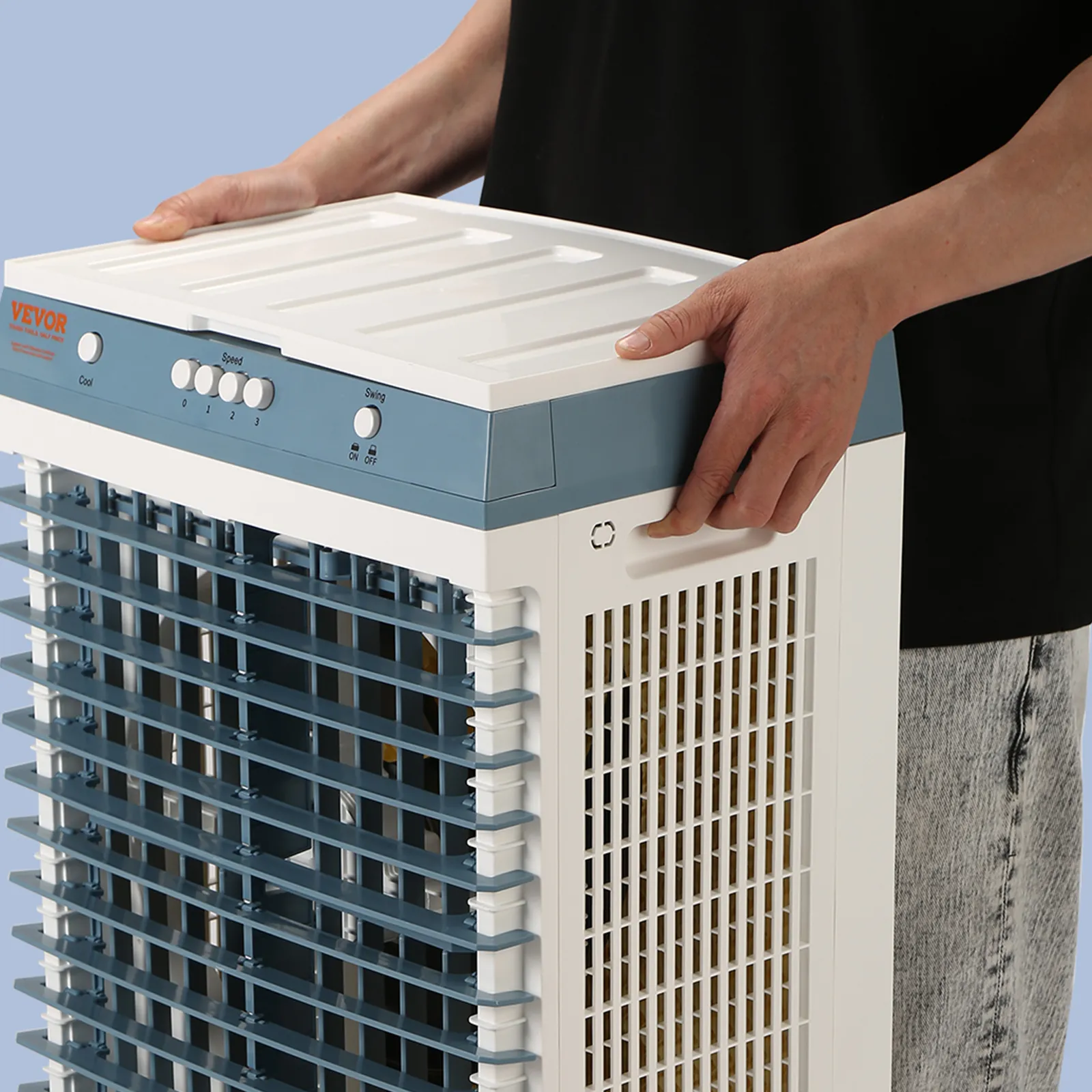 Persona manipulando un enfriador evaporativo VEVOR con paneles ventilados de color blanco y azul.