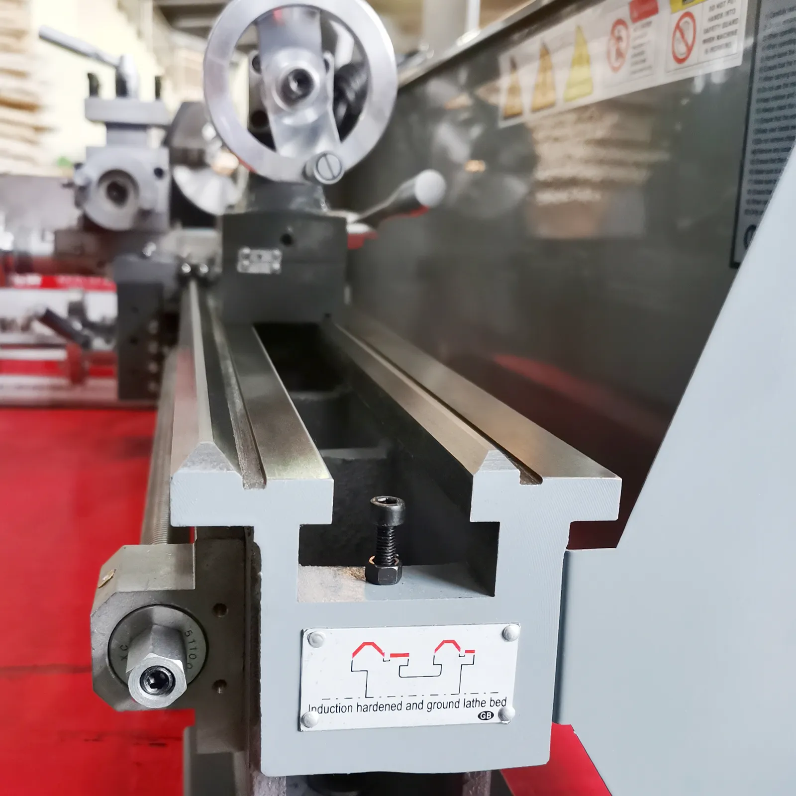 VEVOR metal lathe with precision bed, hardened and ground for accuracy, against a red industrial background.