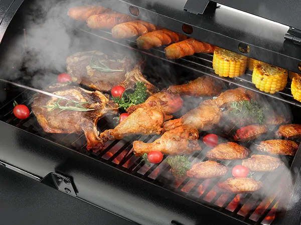 barbecue with lamb chops, chicken, corn, and vegetables grilling on a VEVOR charcoal grill.