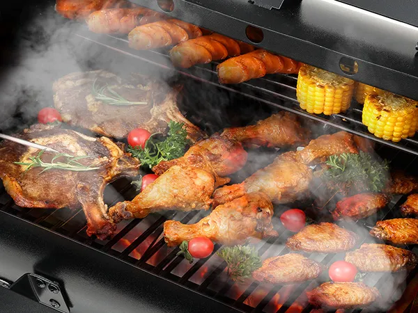 grilling meat, corn, carrots, and tomatoes on a smoky VEVOR heavy duty charcoal grill.