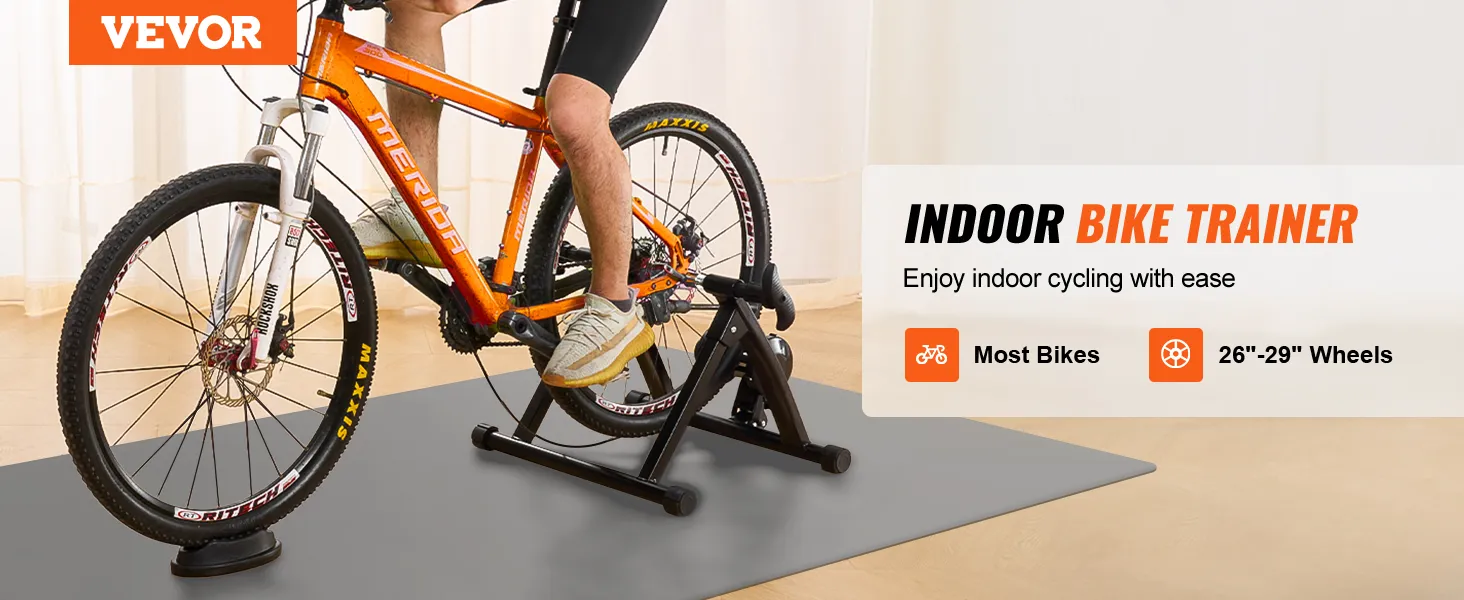 cyclist on VEVOR bike trainer stand with orange bike, promoting indoor cycling for 26"-29" wheels.