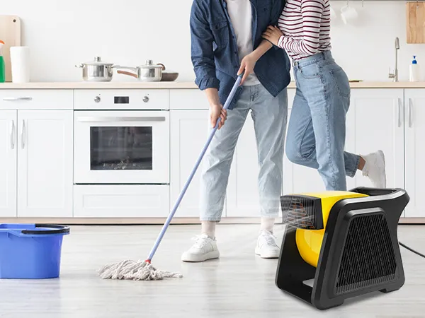trapeando el piso de la cocina con un balde azul y un ventilador multiuso VEVOR secando la superficie.