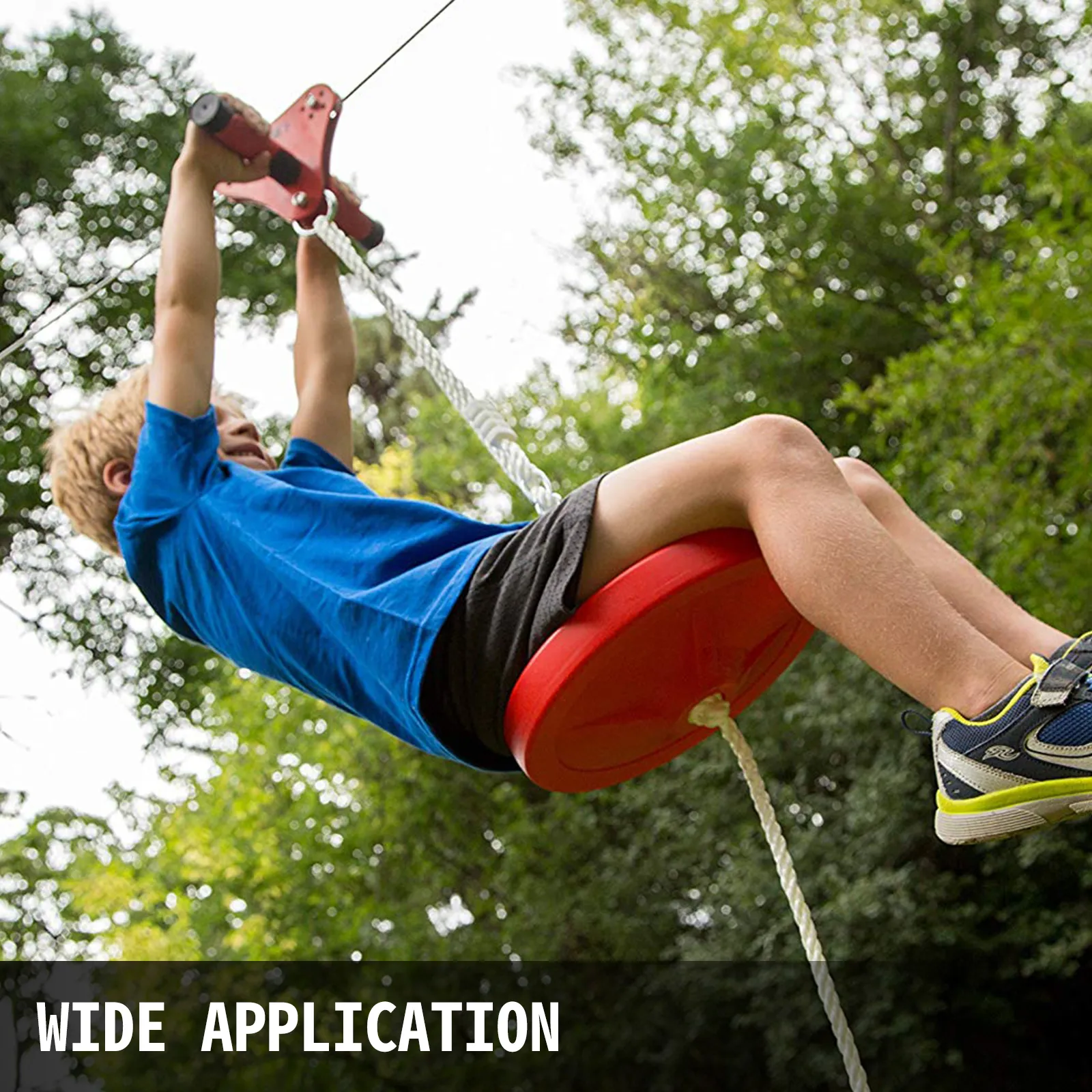Niño disfrutando del kit de tirolina VEVOR en un exuberante entorno verde al aire libre.