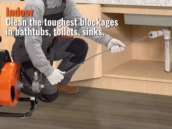 worker using VEVOR drain cleaning machine to clear pipes under a sink in a kitchen cabinet.