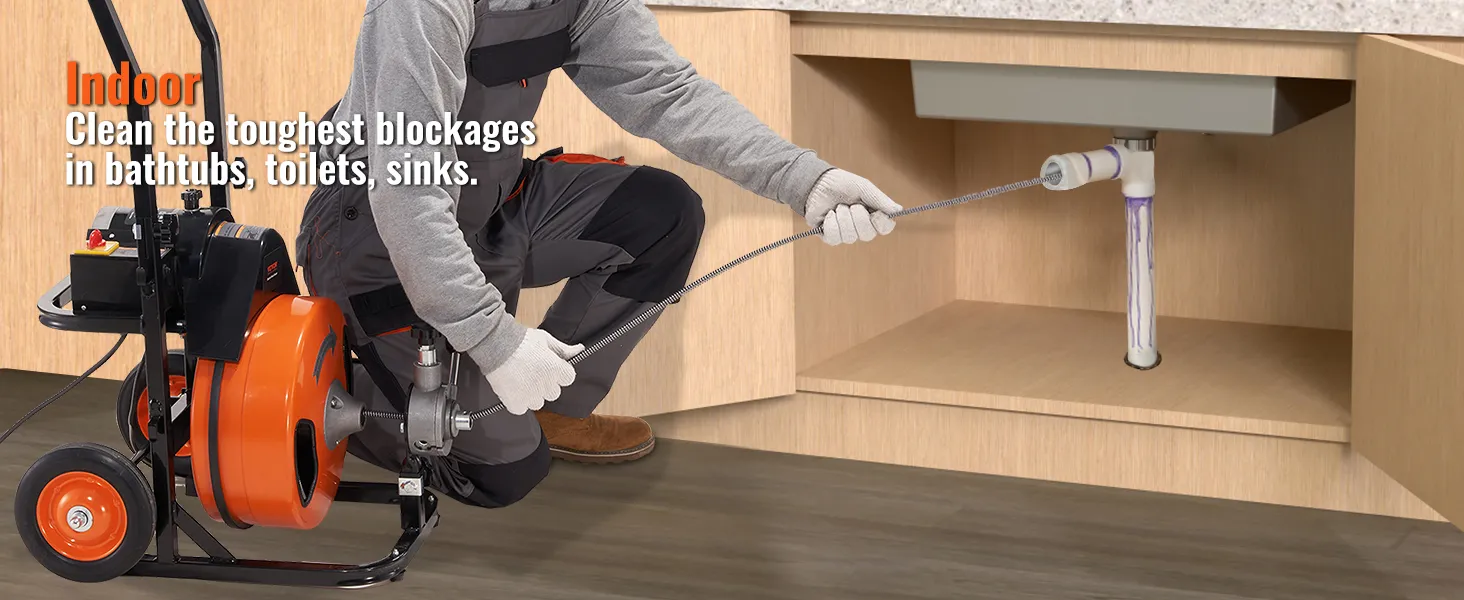 worker using VEVOR drain cleaning machine to clear pipes under a sink in a kitchen cabinet.
