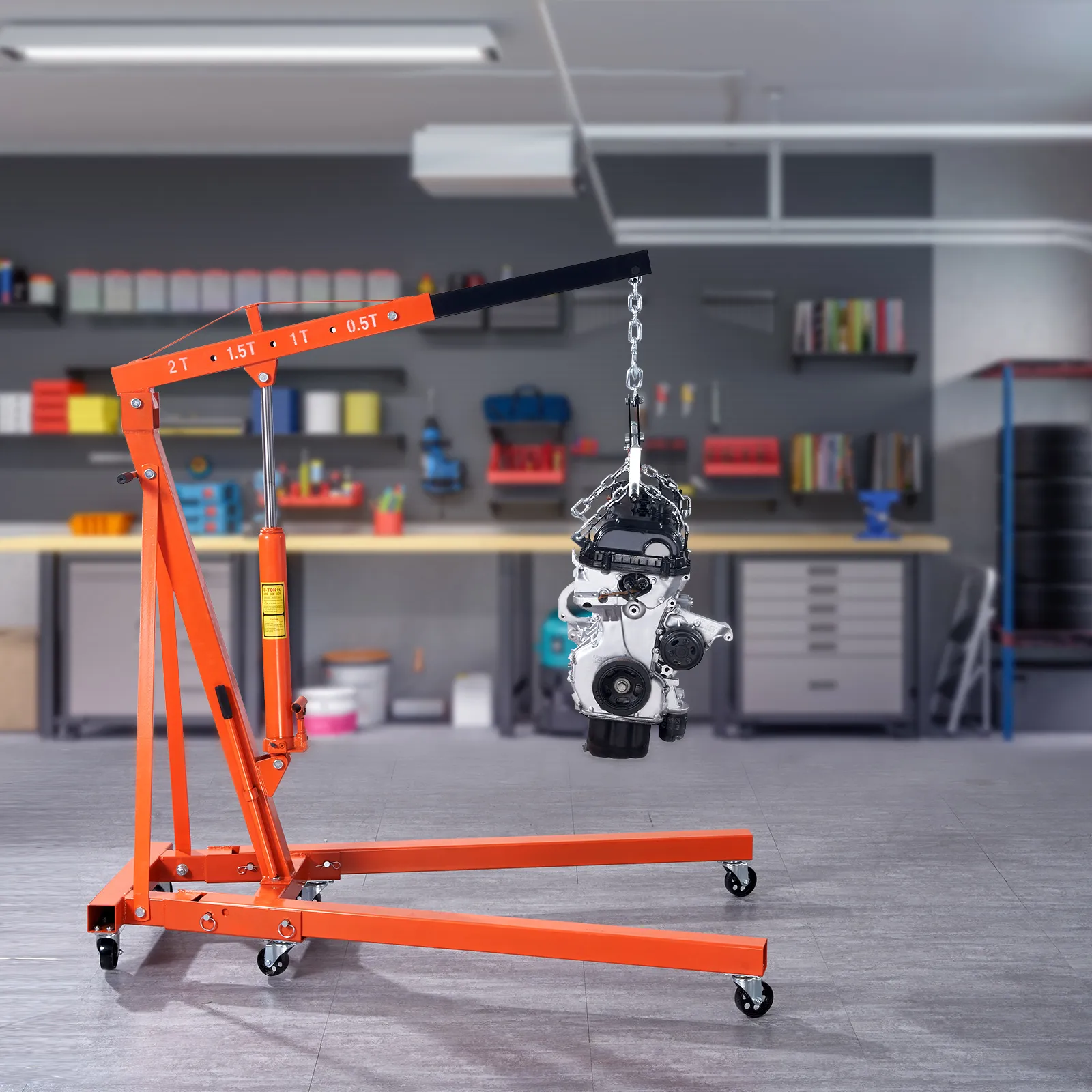 VEVOR hydraulic engine hoist lifting engine in automotive workshop with tools in background.