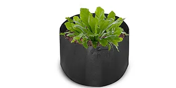 Planta de hojas verdes en una bolsa de cultivo de plantas VEVOR negra.