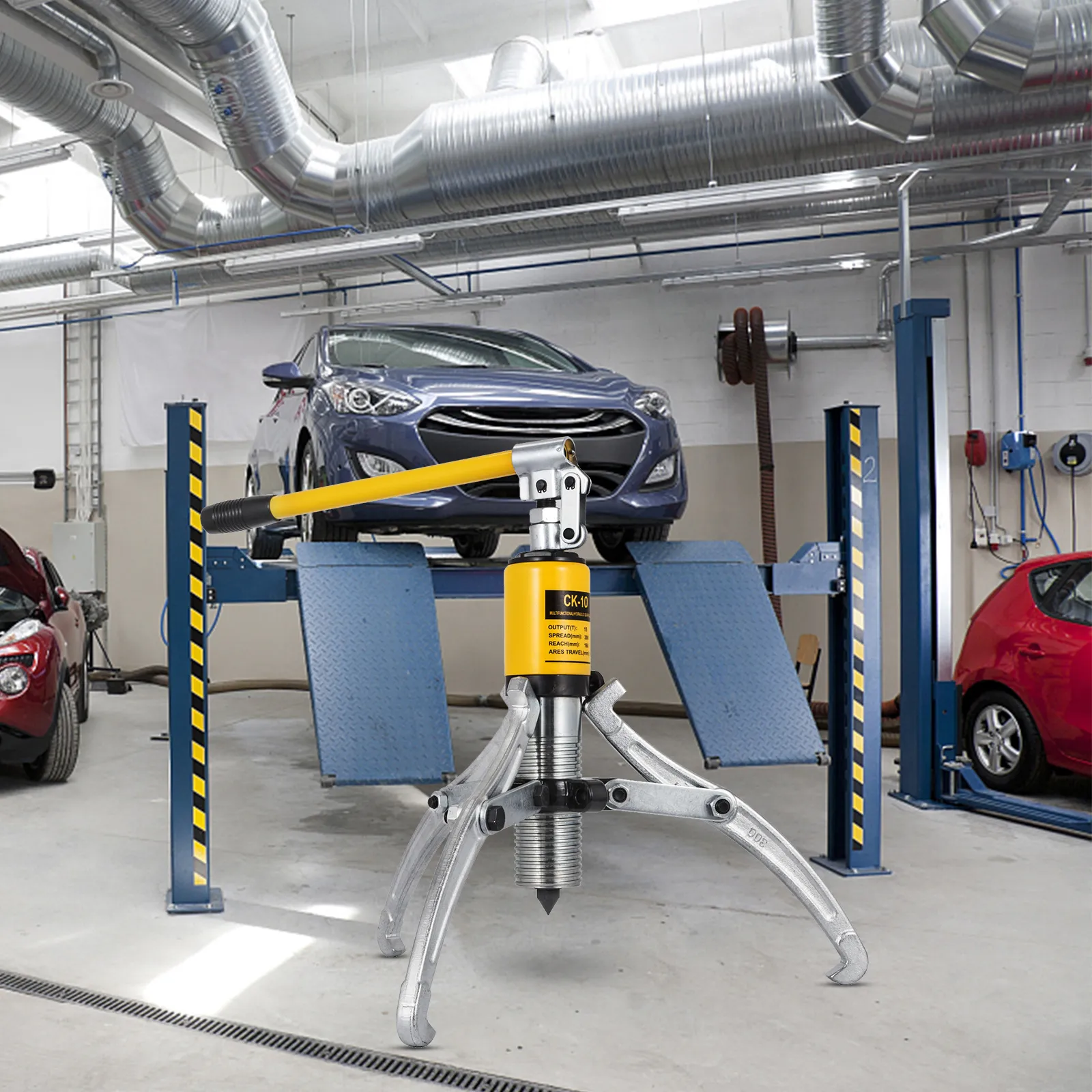 VEVOR hydraulic gear puller in a car repair workshop with vehicles on lifts.